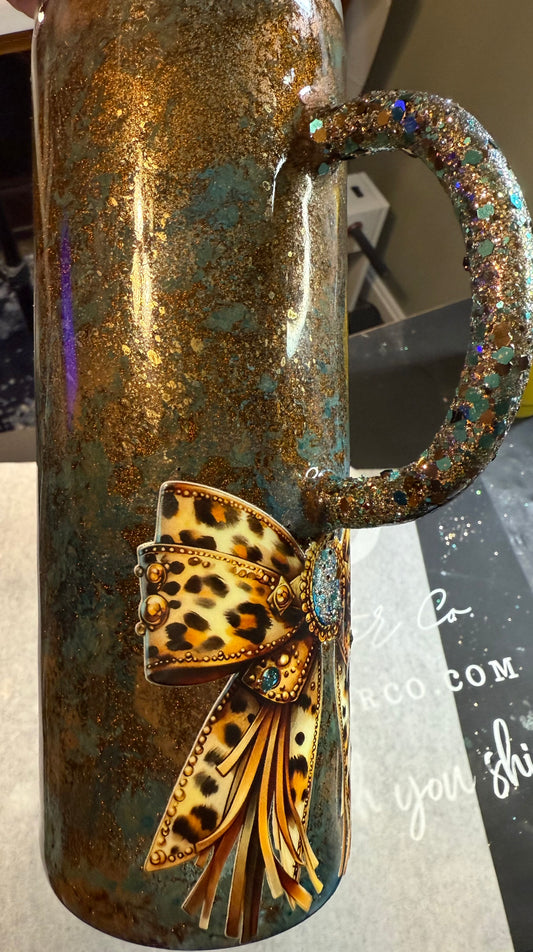 #718. 20 oz Tipsy with a Glittered Handle Western Patina and a Bow Decal